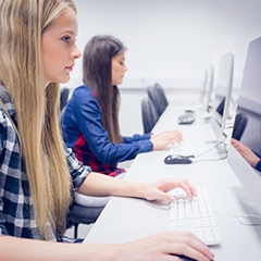 Två tjejer sitter framför dator och arbetar. Foto: Mostphotos